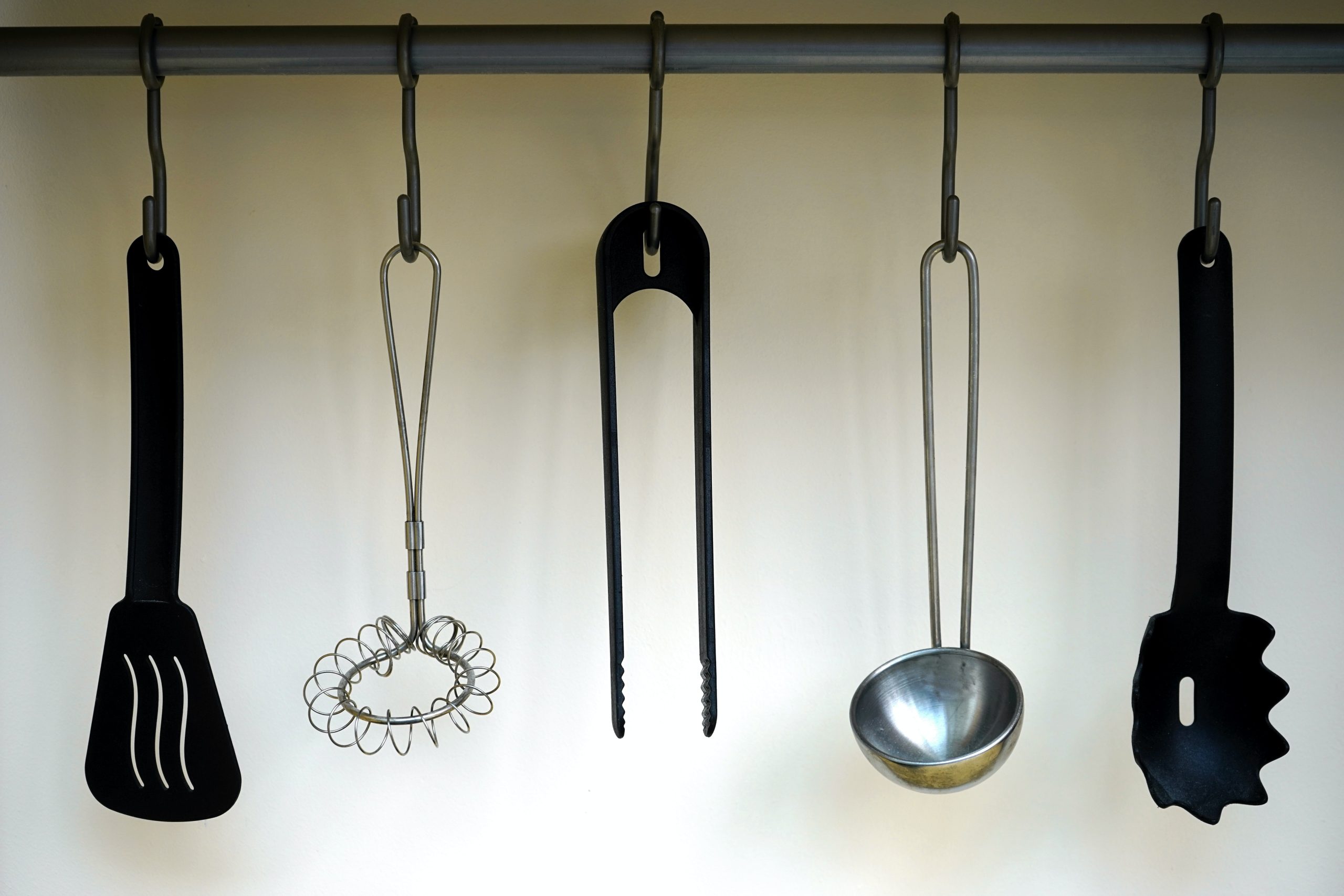 https://edsbred.com/wp-content/uploads/2022/07/utensils-for-cast-iron-pan-hanging-on-the-wall-scaled.jpg